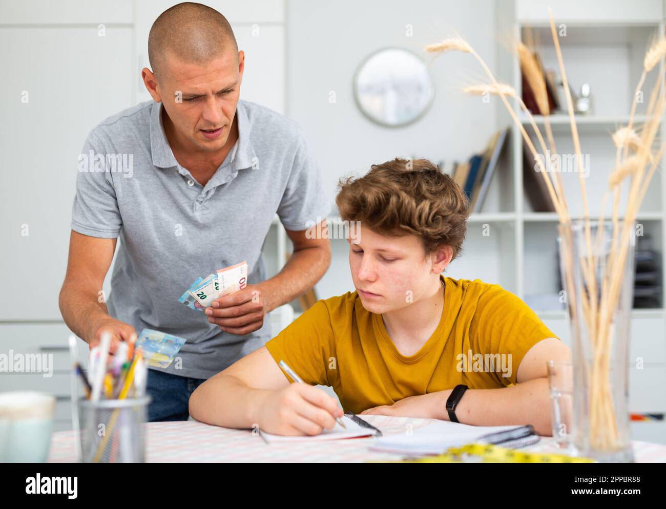 Father giving son money Stock Photo - Alamy