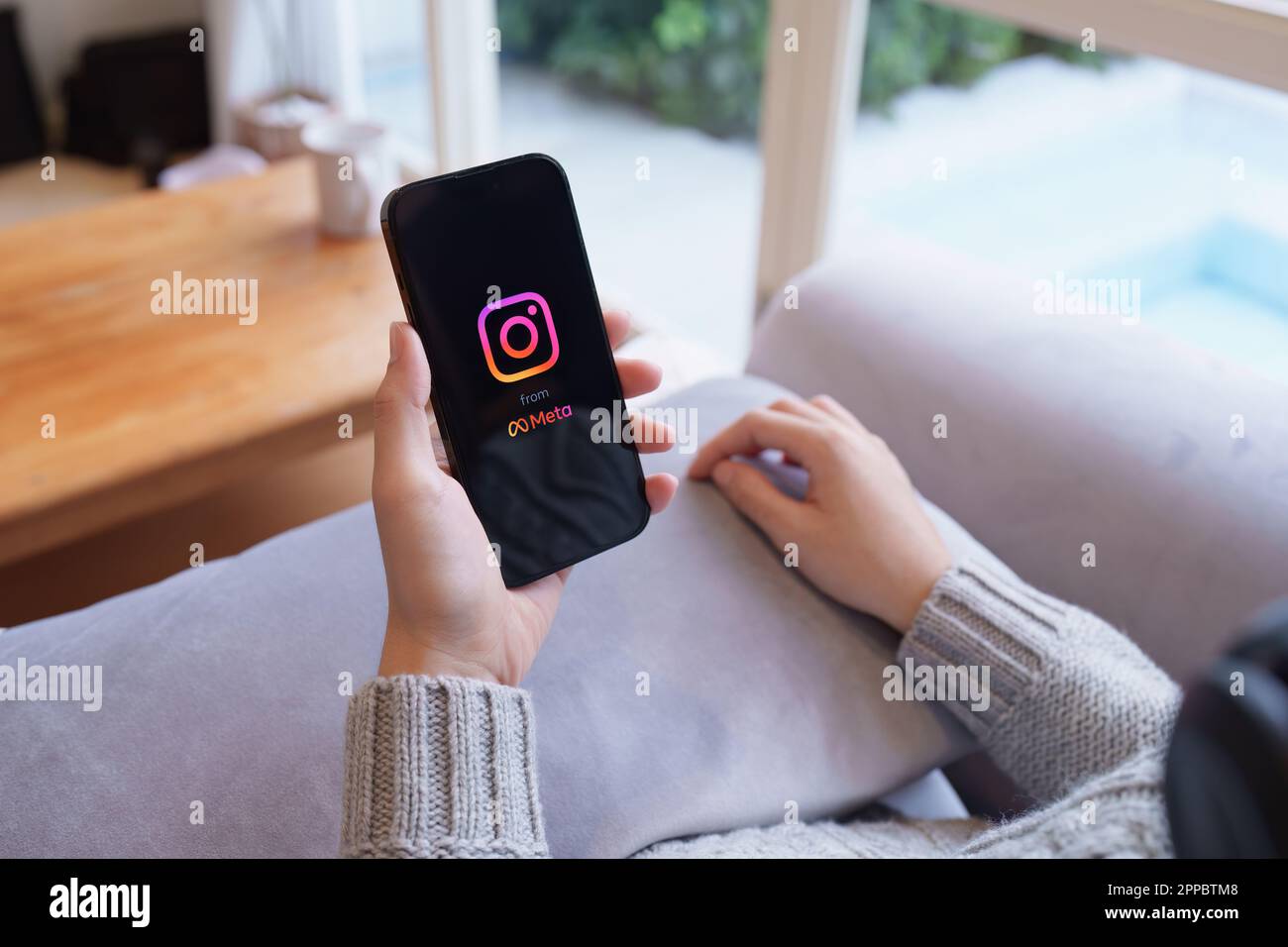 CHIANG MAI, THAILAND - APR 21, 2023: Woman hand using Iphone 14 with Instagram application on the screen by metaverse, Instagram is a photo-sharing Stock Photo