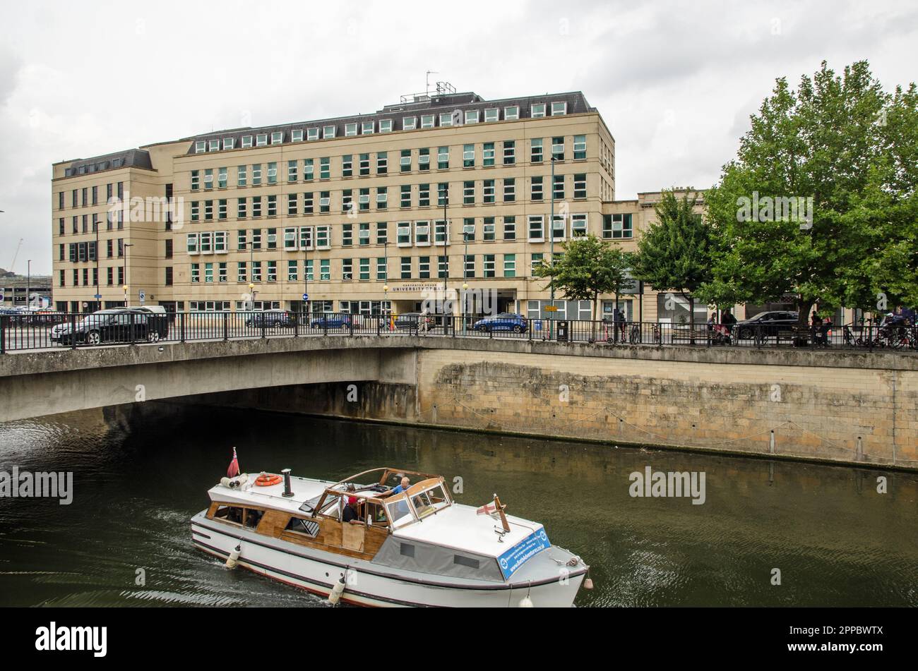 Bath, UK - September 3, 2022: A pleasure boat motoring along the River Avon in front of Carpenter House - part of the University of Bath in Somerset o Stock Photo
