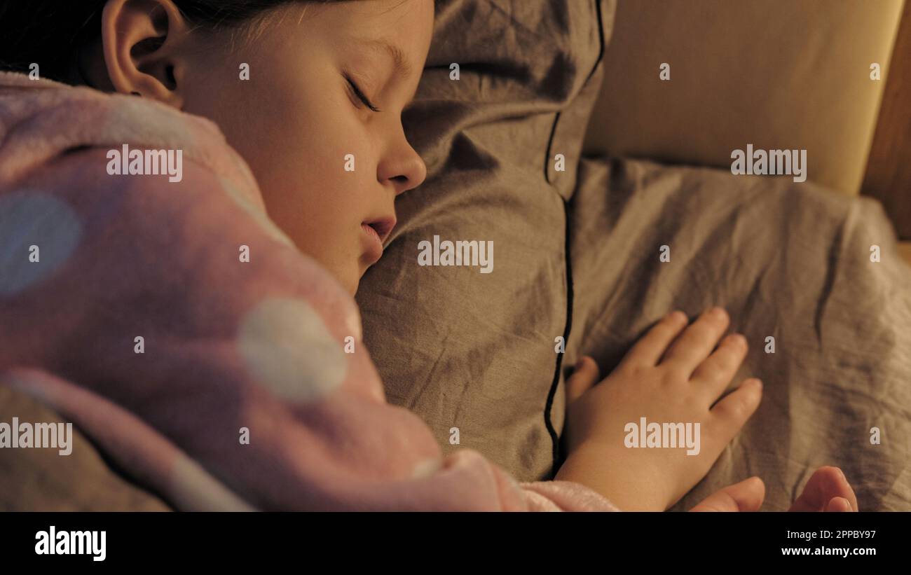 Sleeping kid child rest peaceful small girl in bed Stock Photo