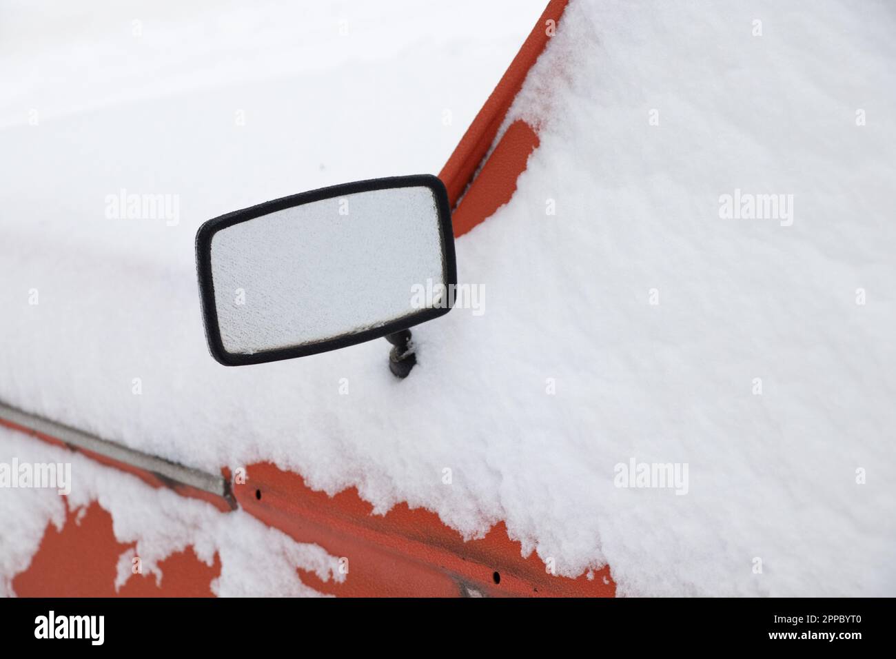 rearview mirror on an old car in the snow in winter in January Stock Photo
