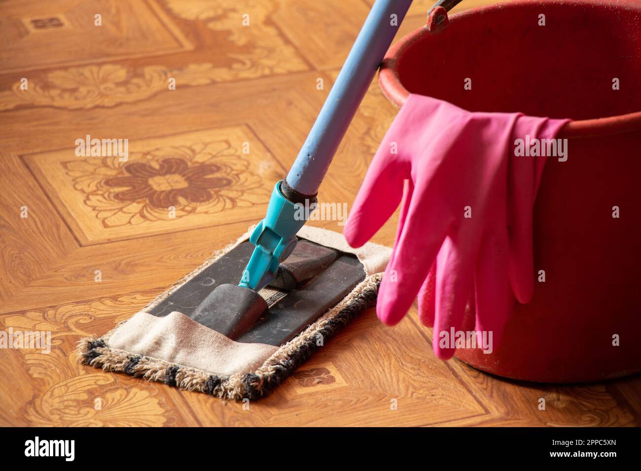 a bucket of gloves and a mop on the floor in the bedroom, cleaning the