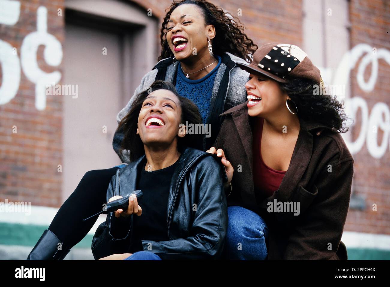 Three African American girlfriends laughing together Stock Photo - Alamy