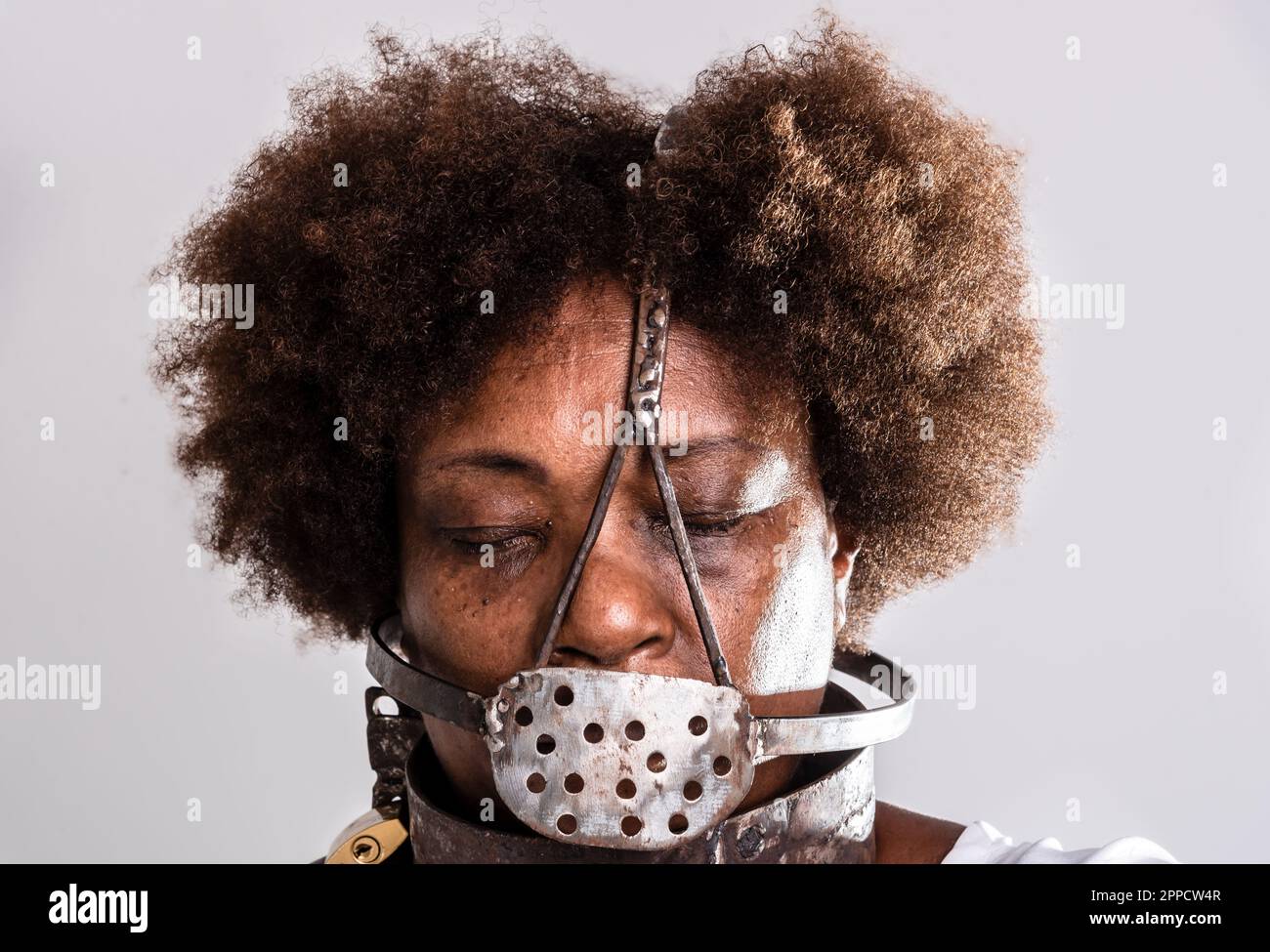 Face portrait of black woman with iron mask of slavery covering her mouth.  Studio reproduction Stock Photo - Alamy