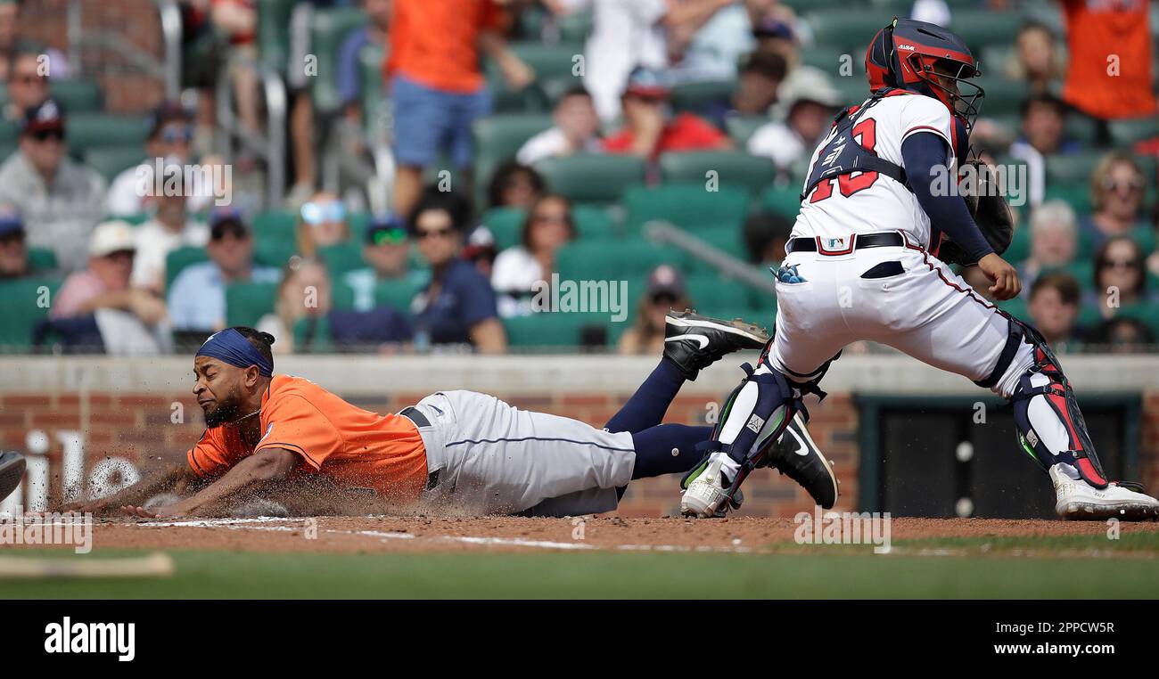 Houston Astros' Corey Julks, left, slides to score behind Atlanta