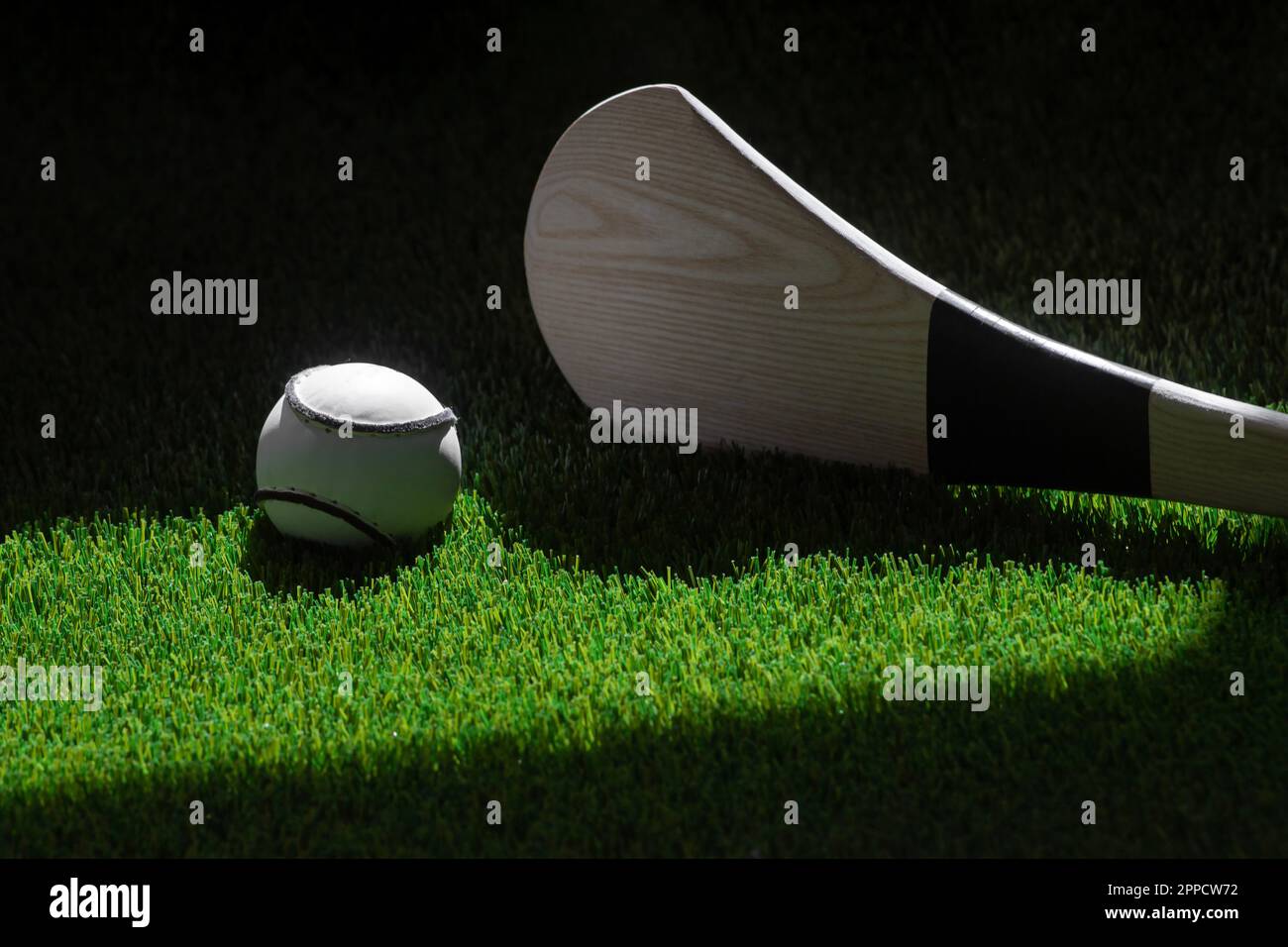 Hurling bat and sloitar on green grass. Horizontal sport theme poster, greeting cards, headers, website and app Stock Photo