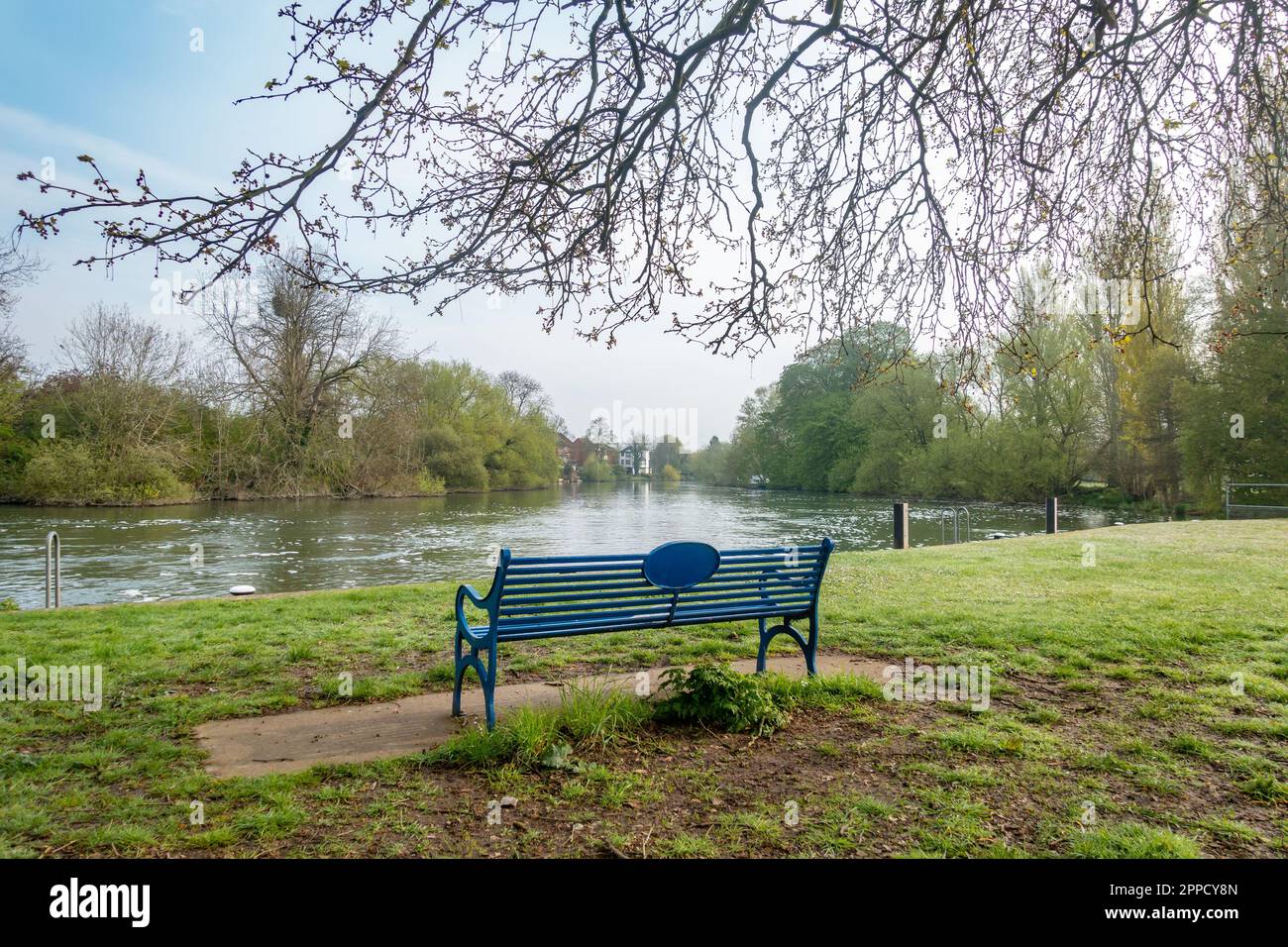 A park bench overlooking The River Thames in Kings Meadow park in Reading, Berkshire, UK Stock Photo