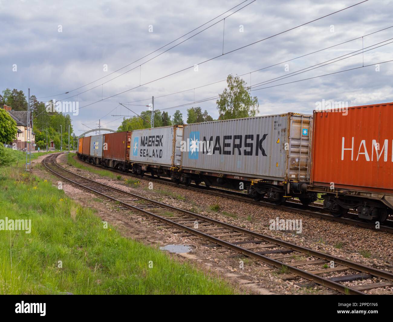 Angelsberg, Sweden - May 28, 2022: A freight train moves slowly along the winding railroad tracks, its cars filled with cargo and rolling stock. The s Stock Photo