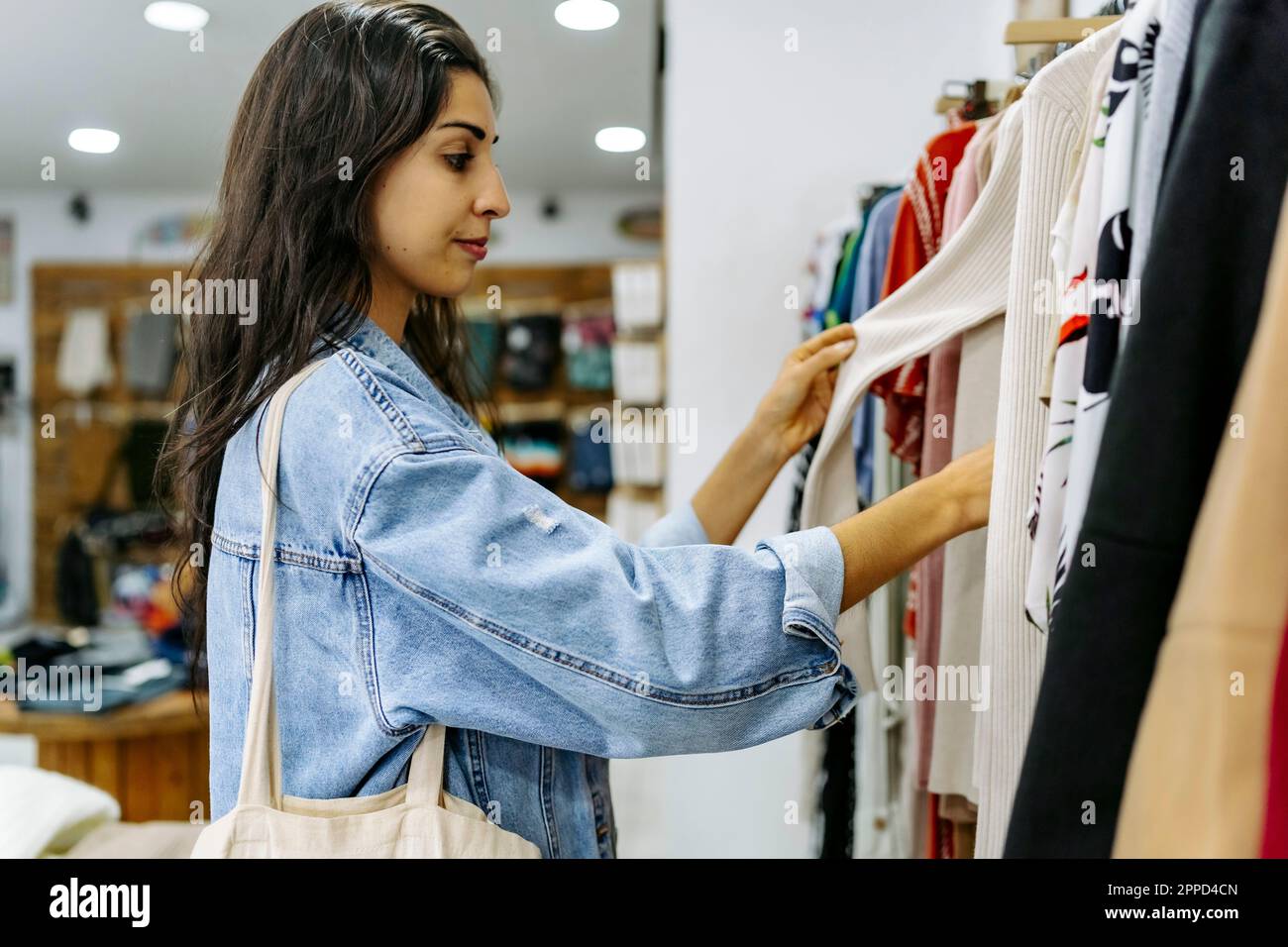 Young woman choosing clothes at store Stock Photo