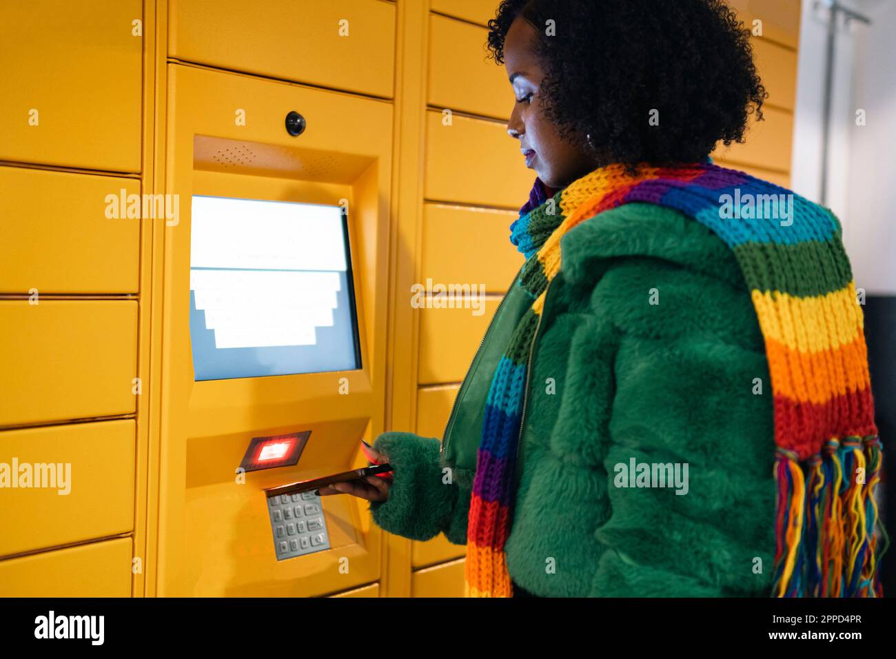Woman paying through smart phone at ticket vending machine Stock Photo ...