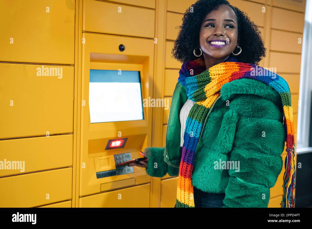 Happy woman standing near ticket vending machine Stock Photo - Alamy