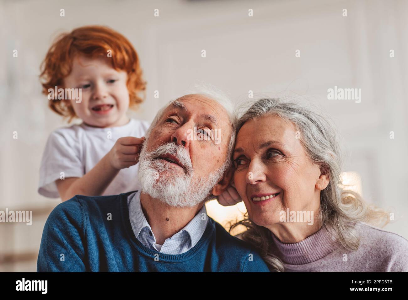 Playful boy with grandparents spending leisure time at home Stock Photo