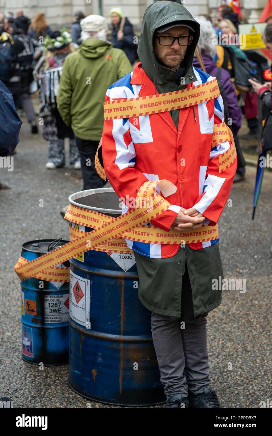 Activist wearing Union Jack jacket tied to Oil Drums outside Department for Business and Trade during 'The Big One' Extinction Rebellion event London. Stock Photo
