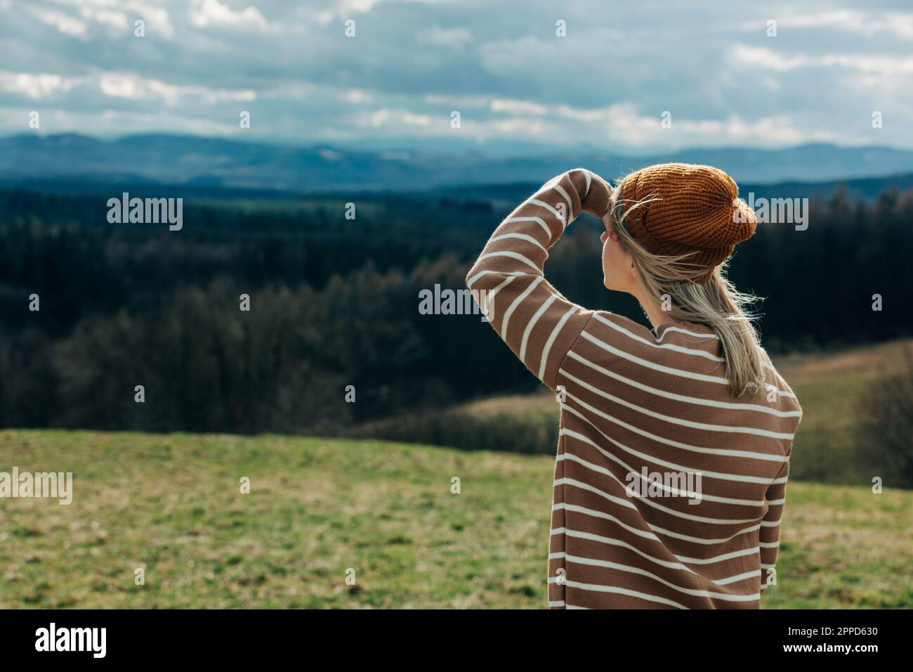 Woman wearing knit hat looking at mountains Stock Photo
