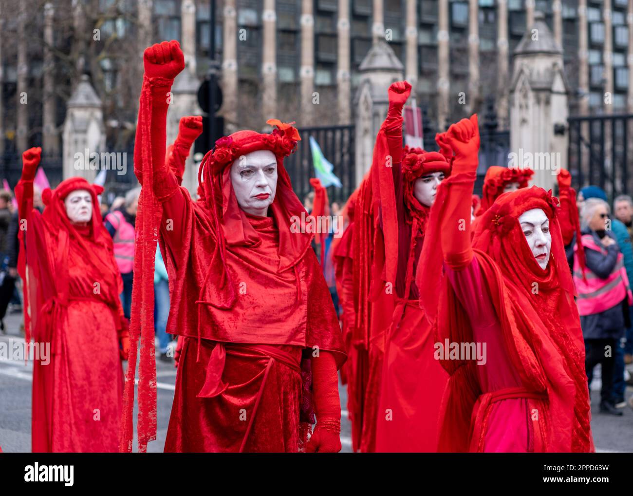 Red Rebel Brigade, performance activists march past the Houses of Parliament/Westminster as part of 'The Big One' Extinction Rebellion protest April. Stock Photo