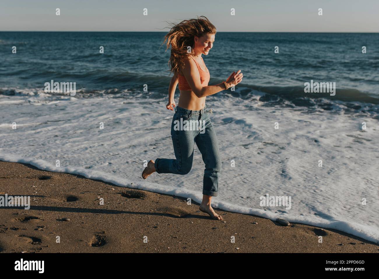 Happy woman running and enjoying at beach Stock Photo