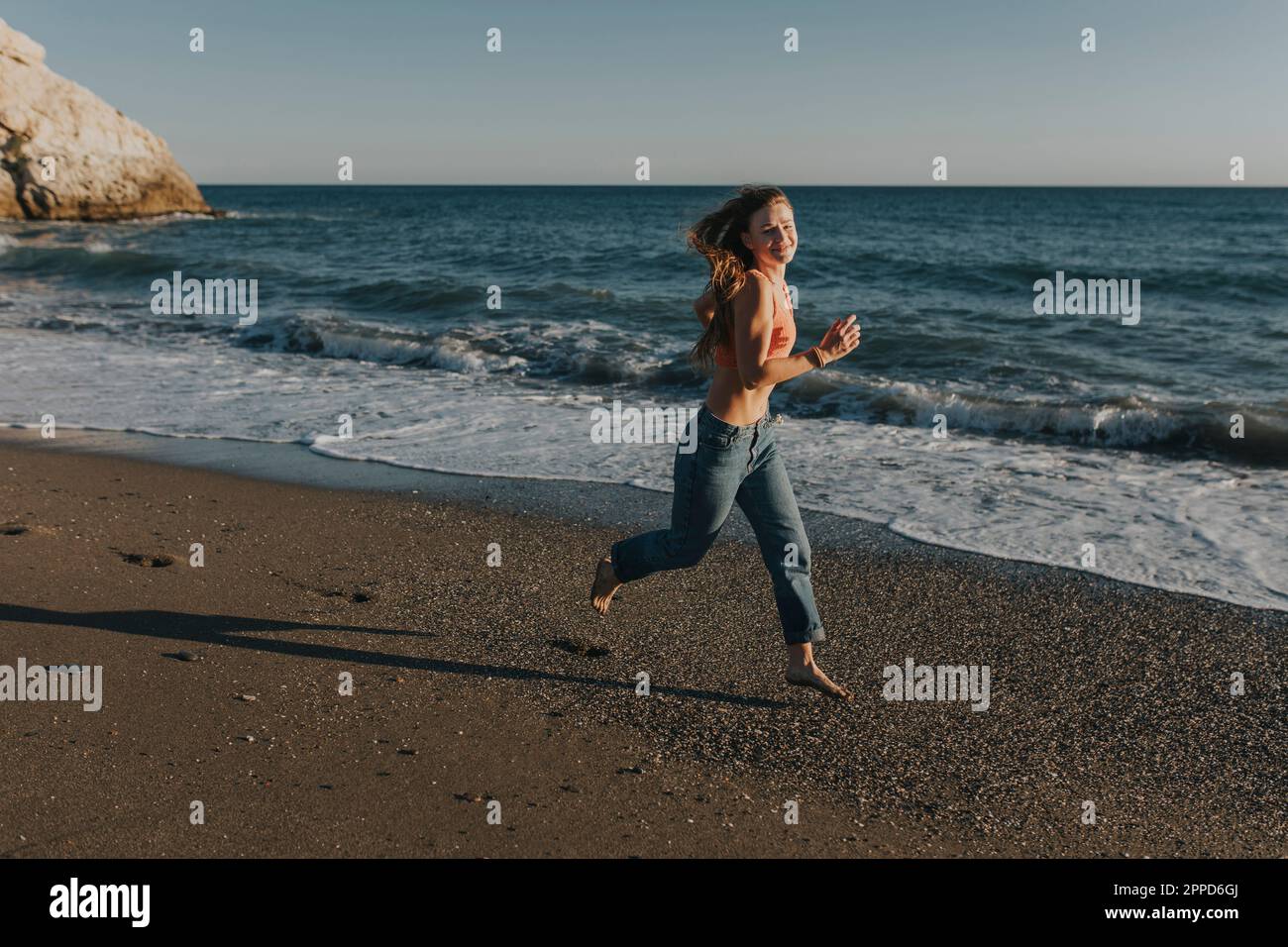 Happy woman running at beach Stock Photo