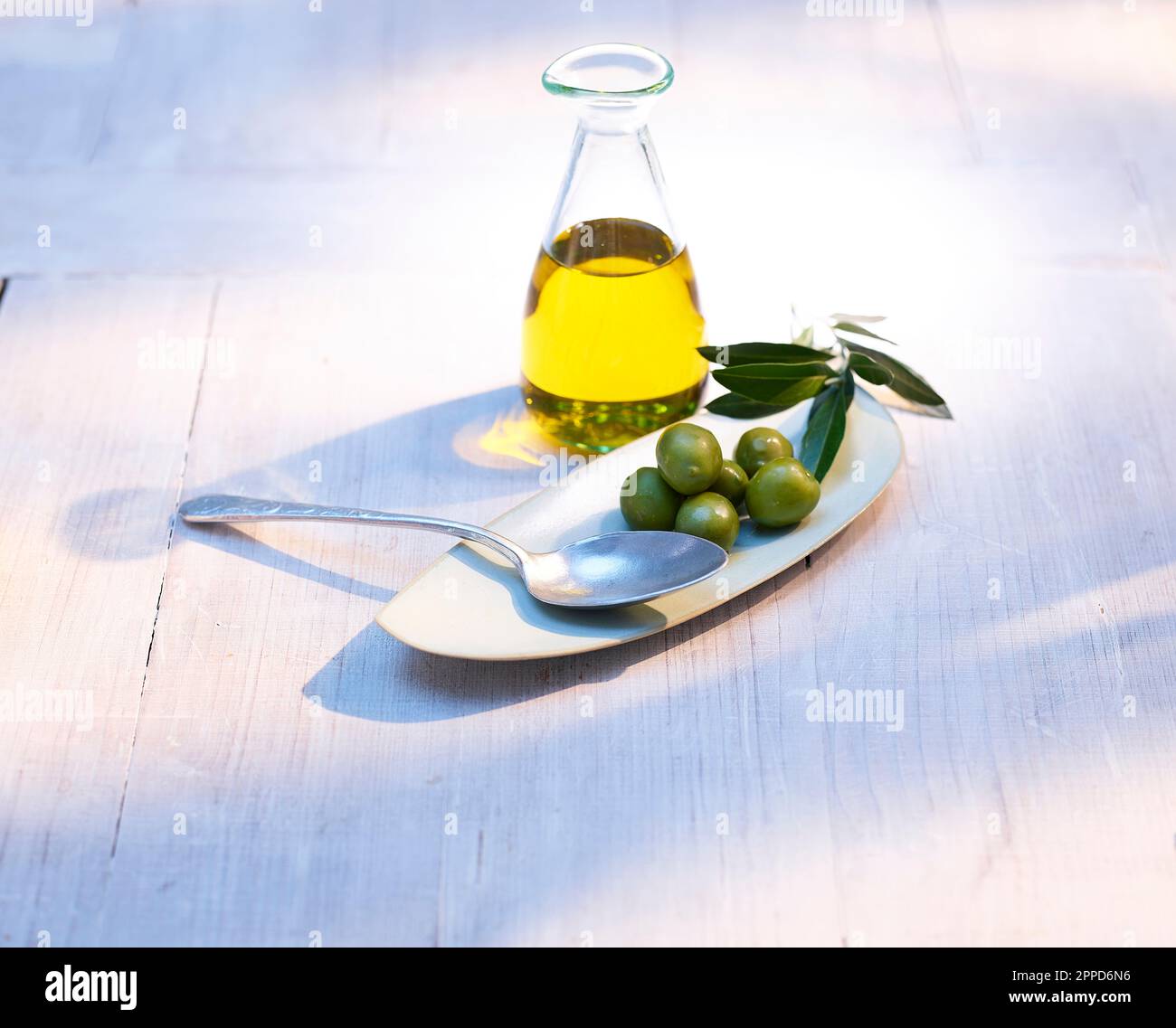 Spoon, raw olives and carafe of olive oil Stock Photo - Alamy