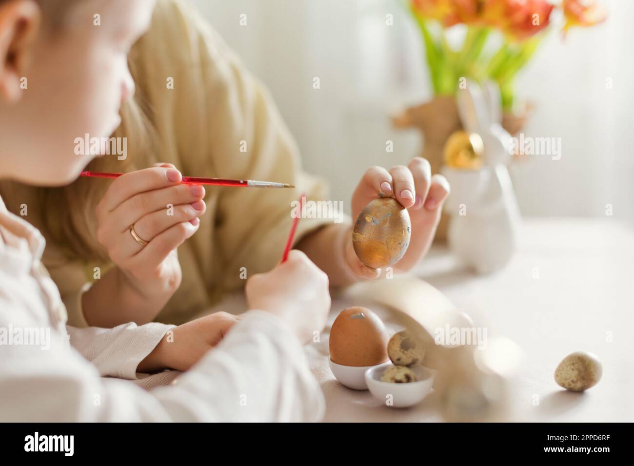 Mother and son decorating Easter eggs at home Stock Photo