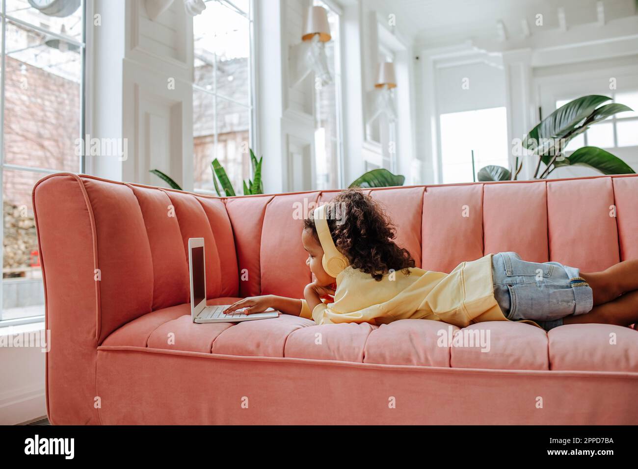 Girl lying on sofa laptop hi-res stock photography and images - Alamy