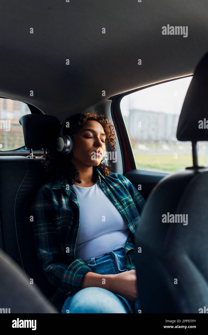 Young woman with eyes closed relaxing in car Stock Photo