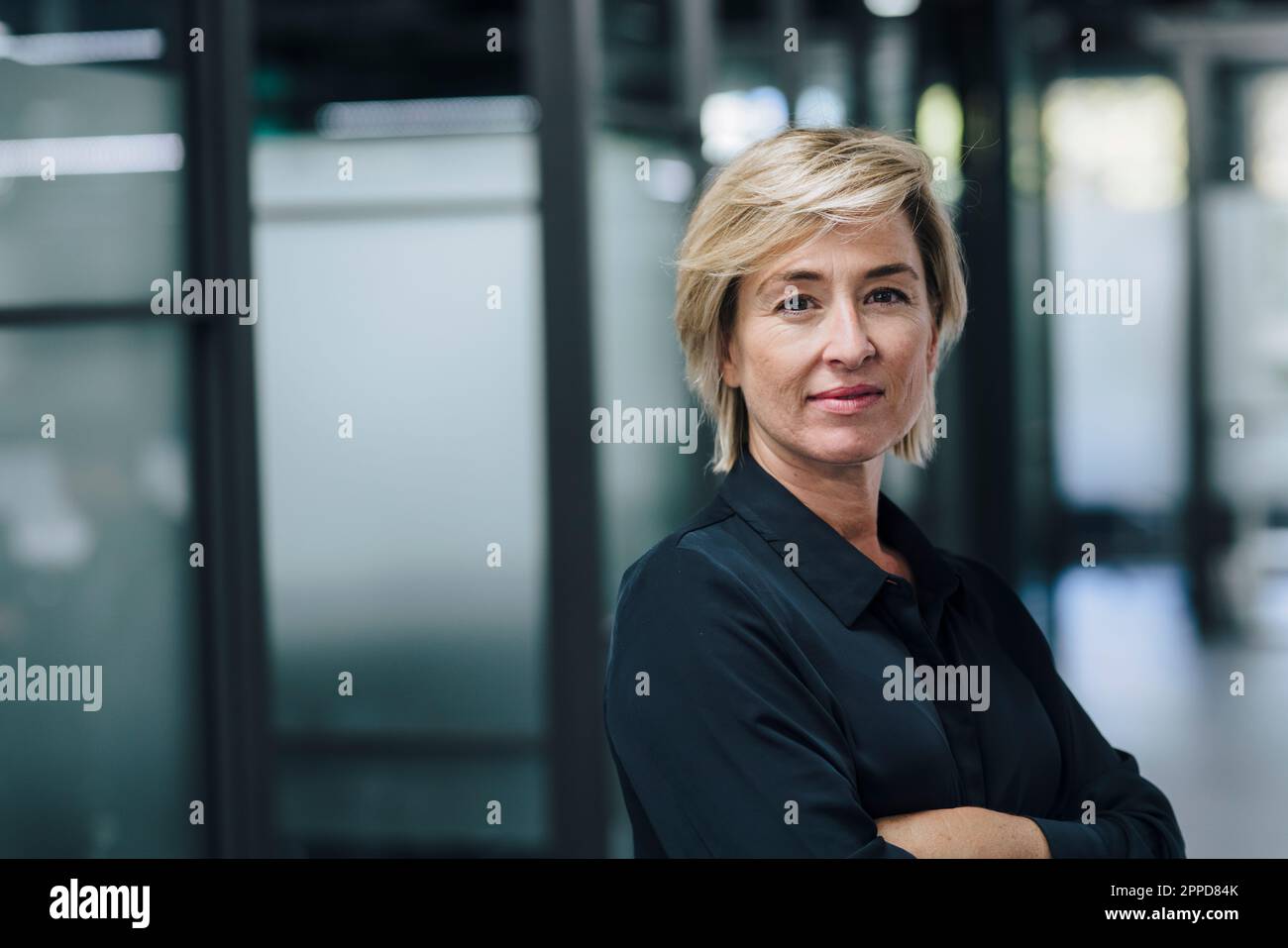 Confident businesswoman with arms crossed in office Stock Photo - Alamy