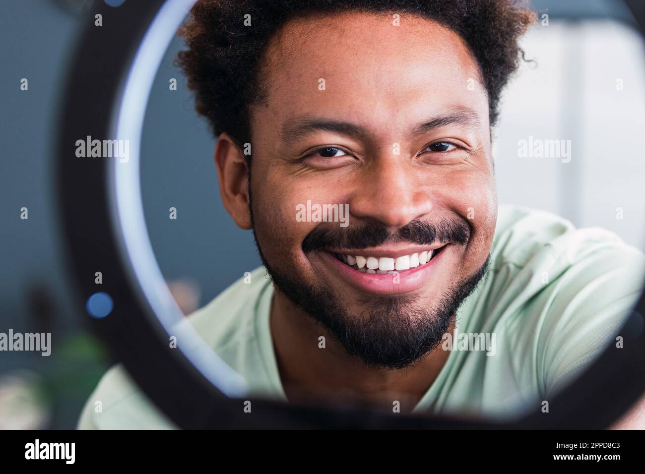 Happy man behind ring light at home Stock Photo Alamy