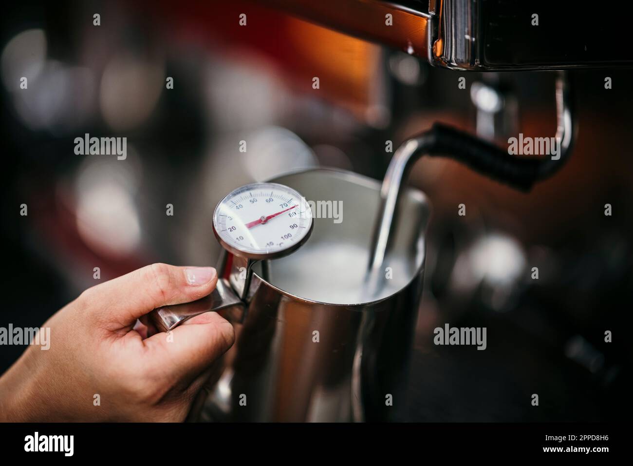 Barista checking temperature of steaming milk Stock Photo Alamy