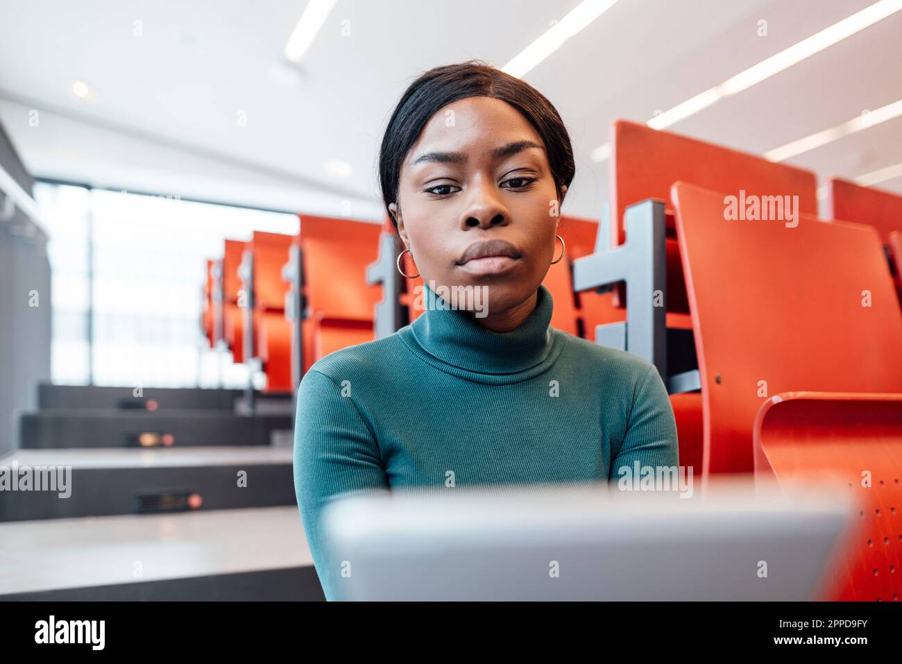 Young woman using tablet PC in auditorium Stock Photo