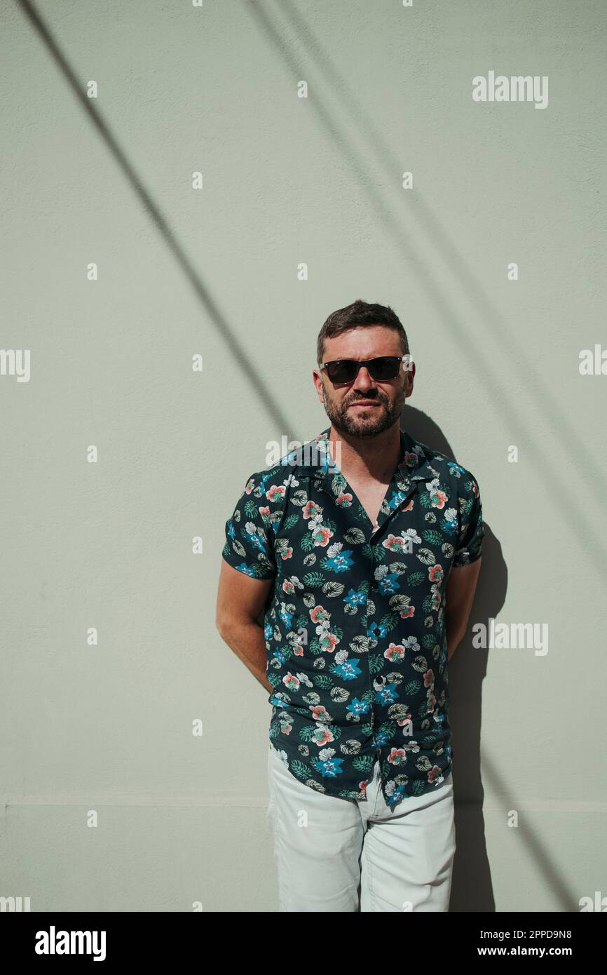 Man wearing sunglasses standing in front of wall Stock Photo - Alamy