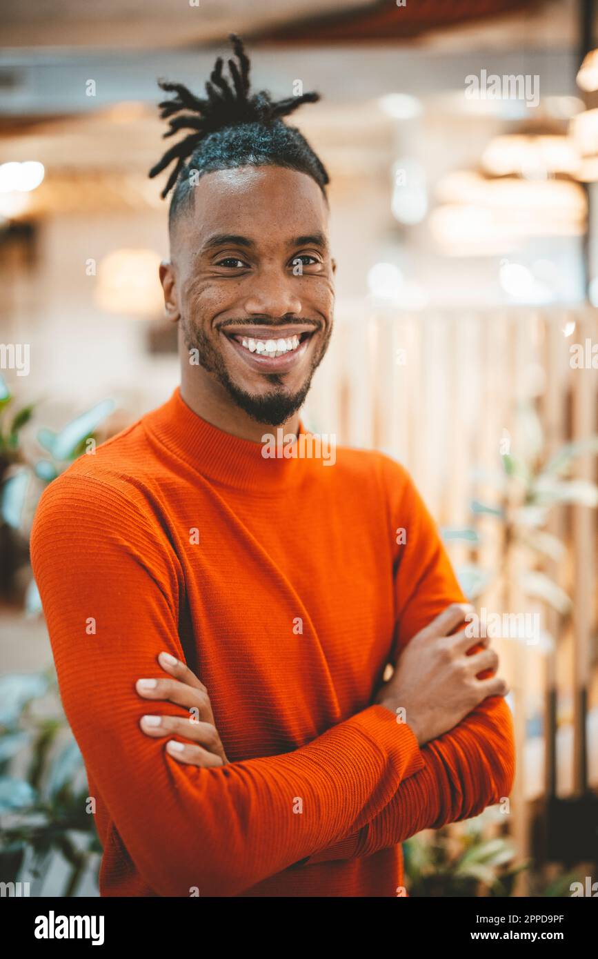 Happy young businessman with arms crossed in office Stock Photo - Alamy