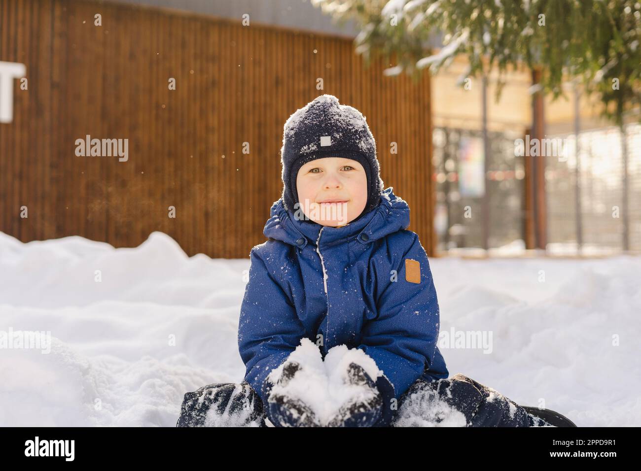 Cute boy wearing knit hat holding snowball Stock Photo