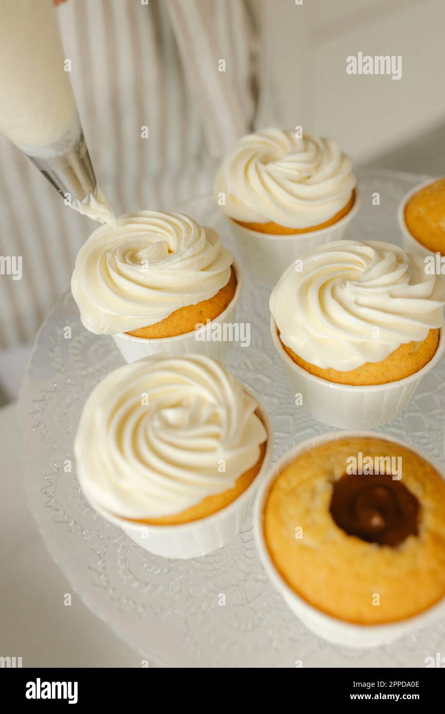 Decorated cupcakes with whipped cream on table Stock Photo