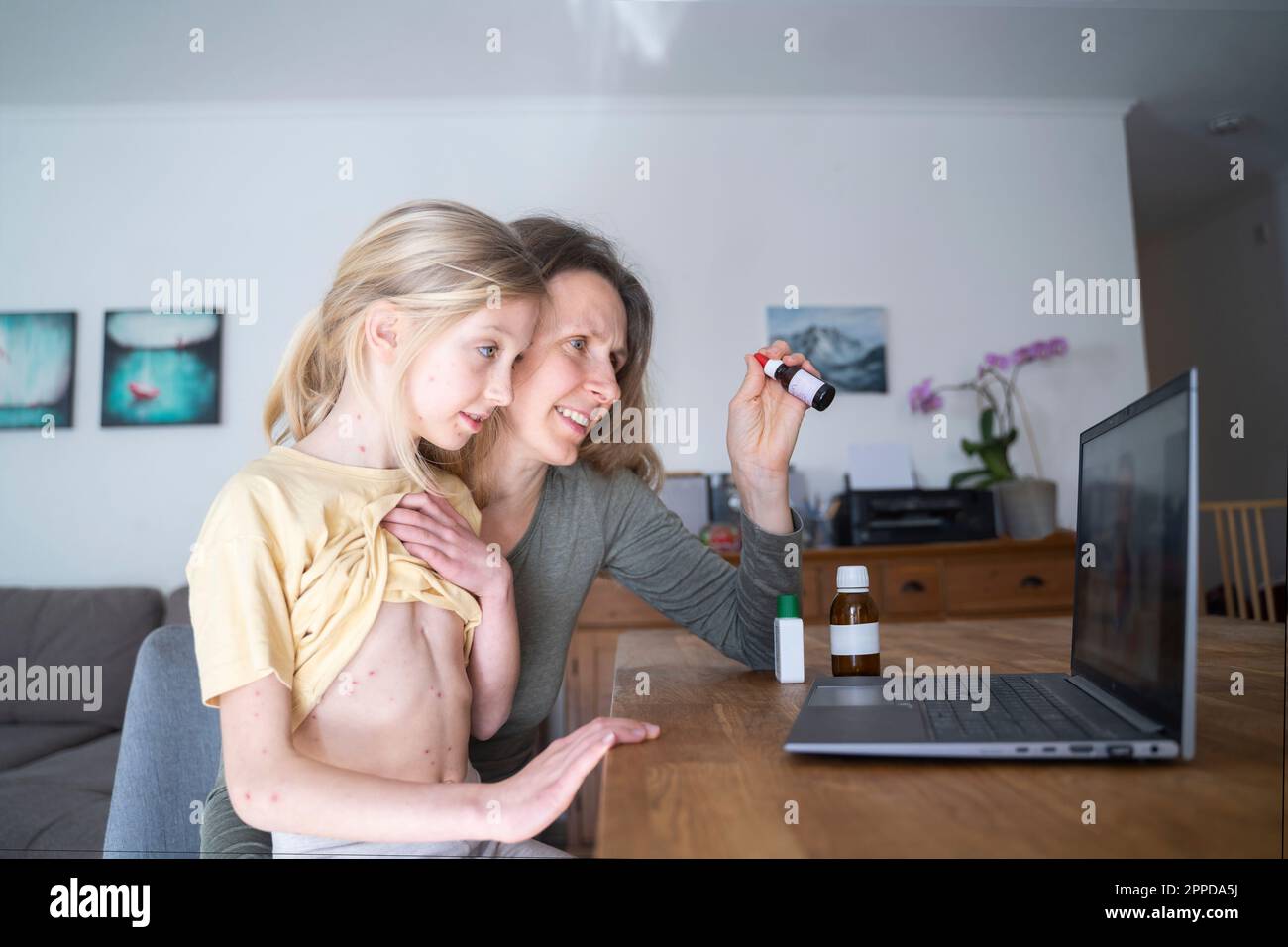 Girl with mother consulting doctor online Stock Photo