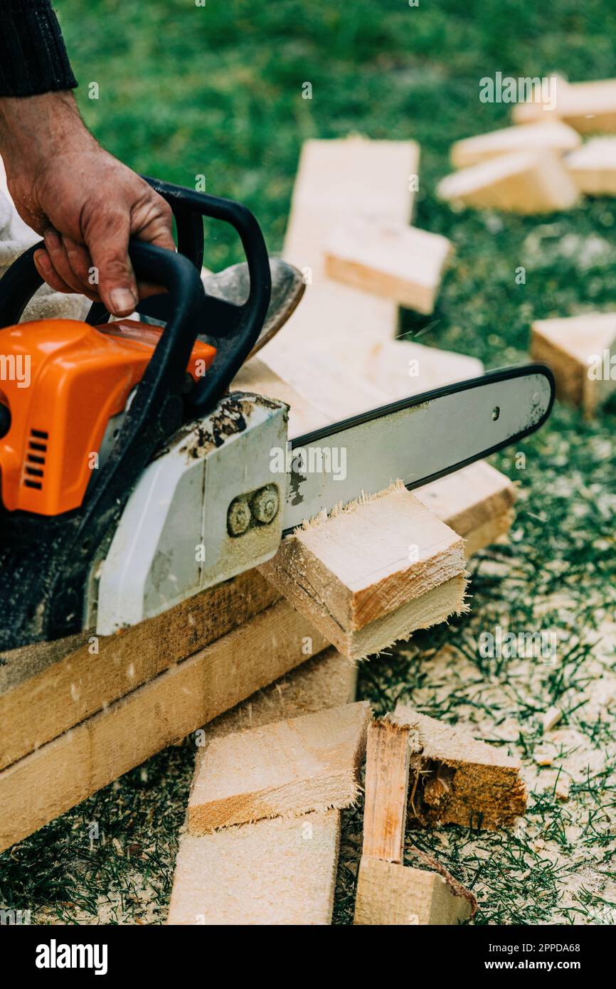 Hand of carpenter cutting wood with chainsaw Stock Photo Alamy