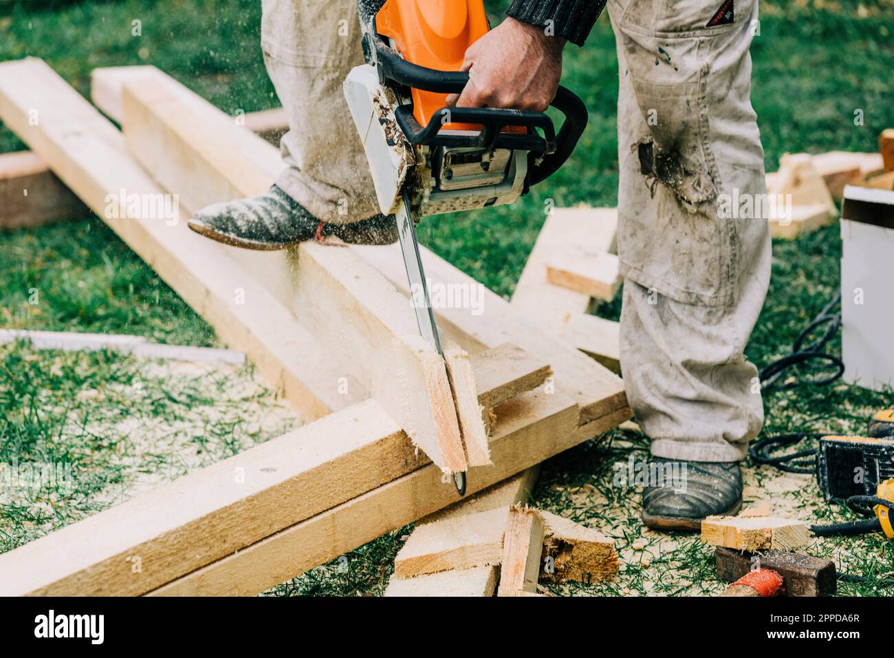 Carpenter cutting wooden planks with chainsaw Stock Photo Alamy