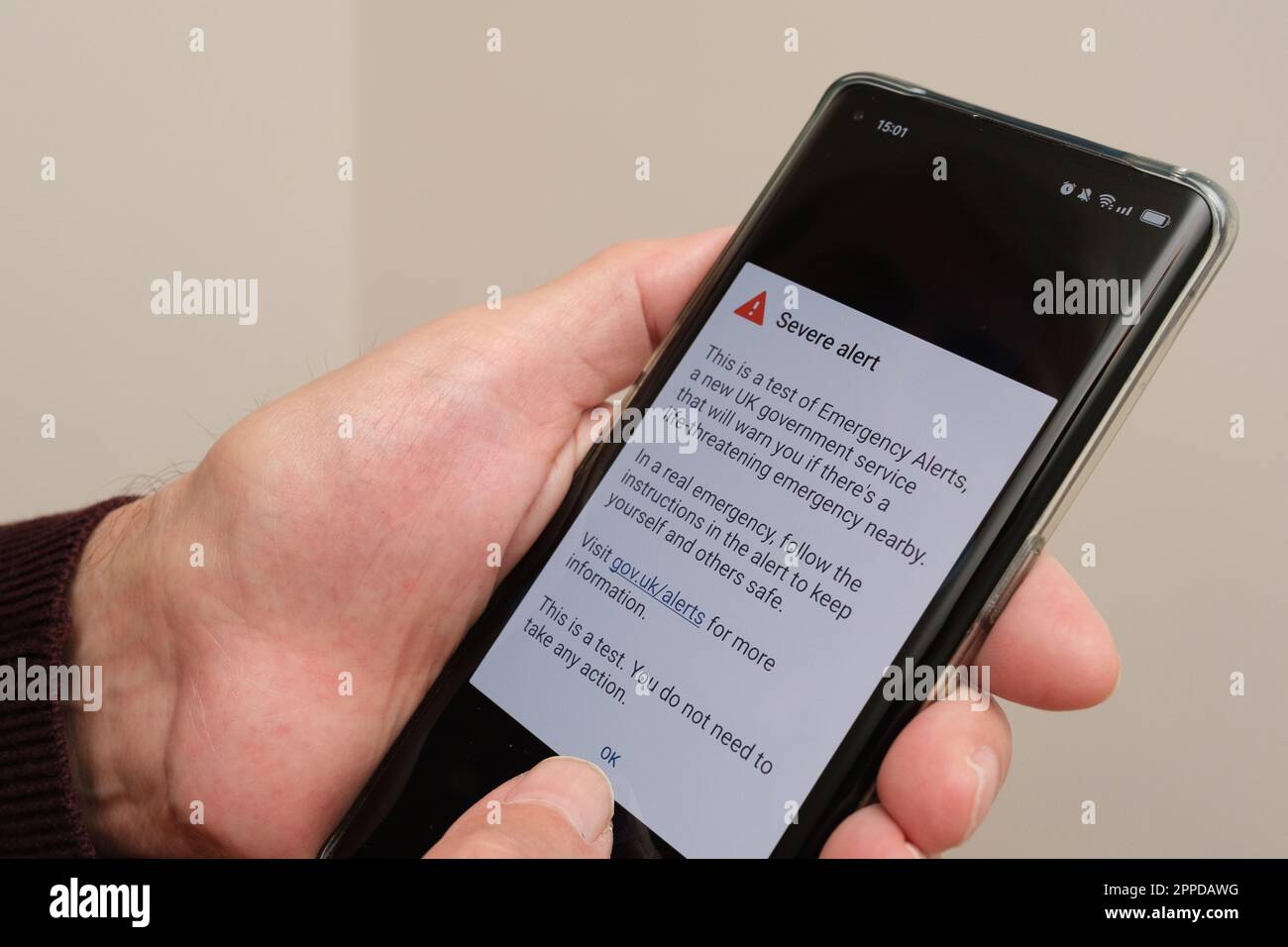 Severe Alert seen on the screen of smartphone hold in hand of elderly