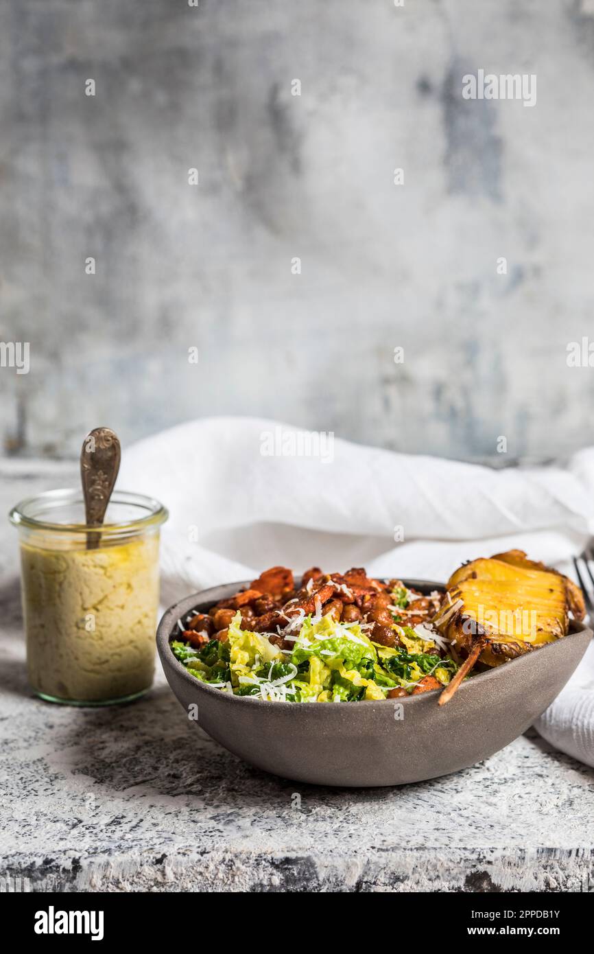 Bowl of salad with roasted chickpeas, carrots and roasted potato on skewer Stock Photo