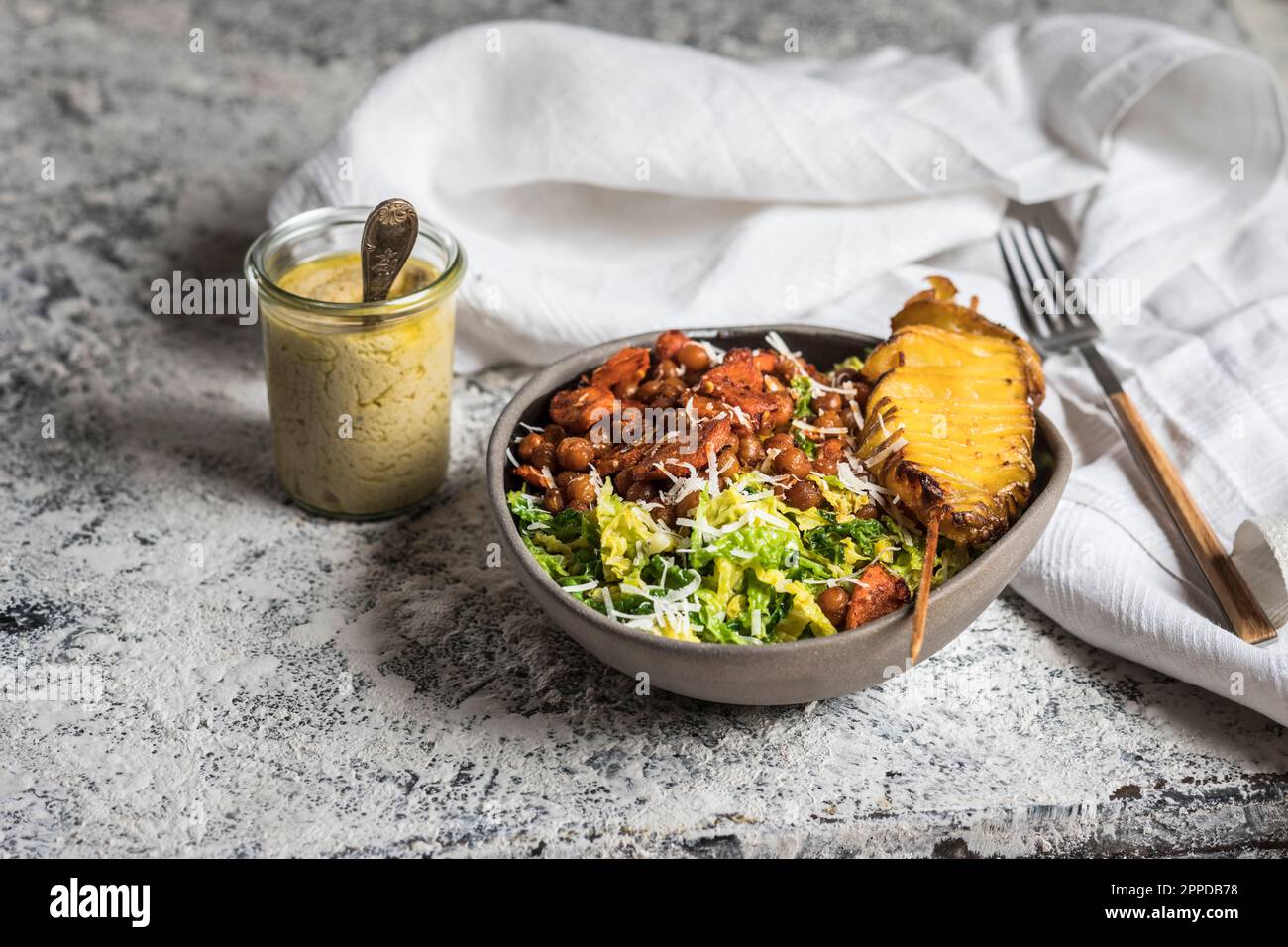 Bowl of salad with roasted chickpeas, carrots and roasted potato on skewer Stock Photo