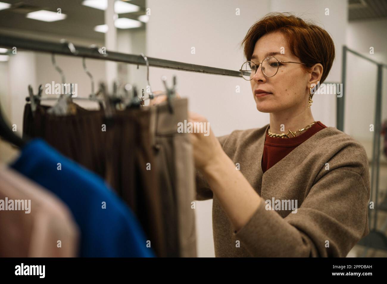 Woman wearing eyeglasses working in clothes store Stock Photo