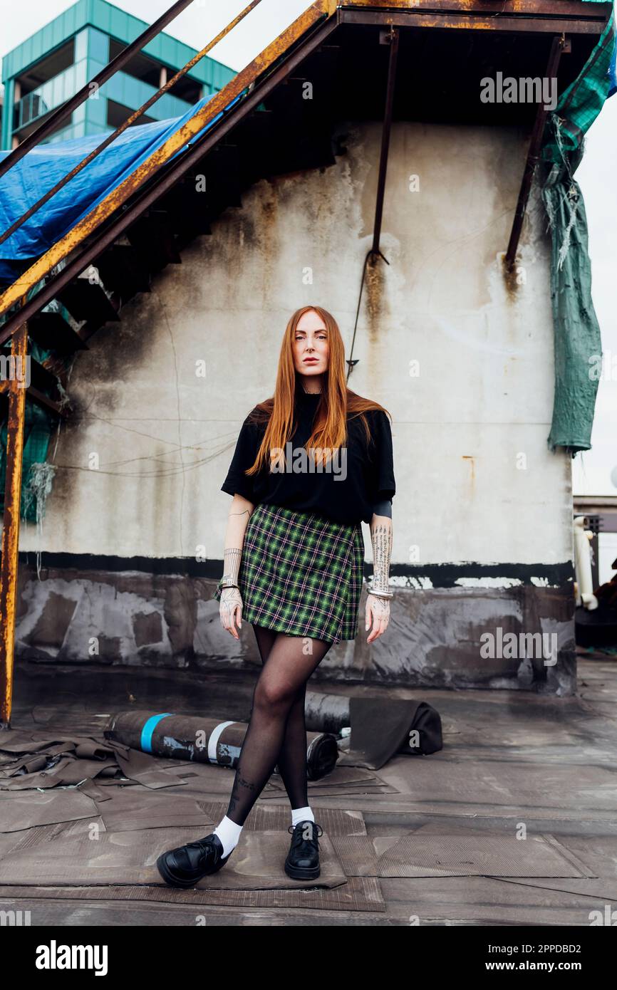 Redhead woman with legs crossed standing at terrace Stock Photo Alamy