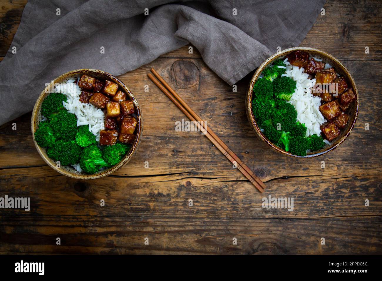 Two bowls of coconut rice with tofu, broccoli and sesame seeds Stock Photo