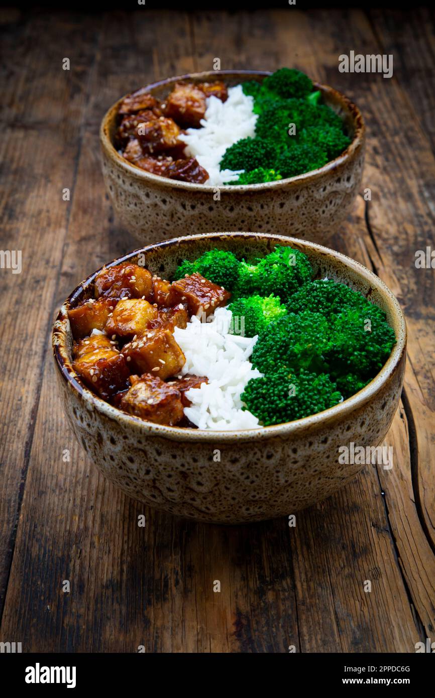 Two bowls of coconut rice with tofu, broccoli and sesame seeds Stock Photo