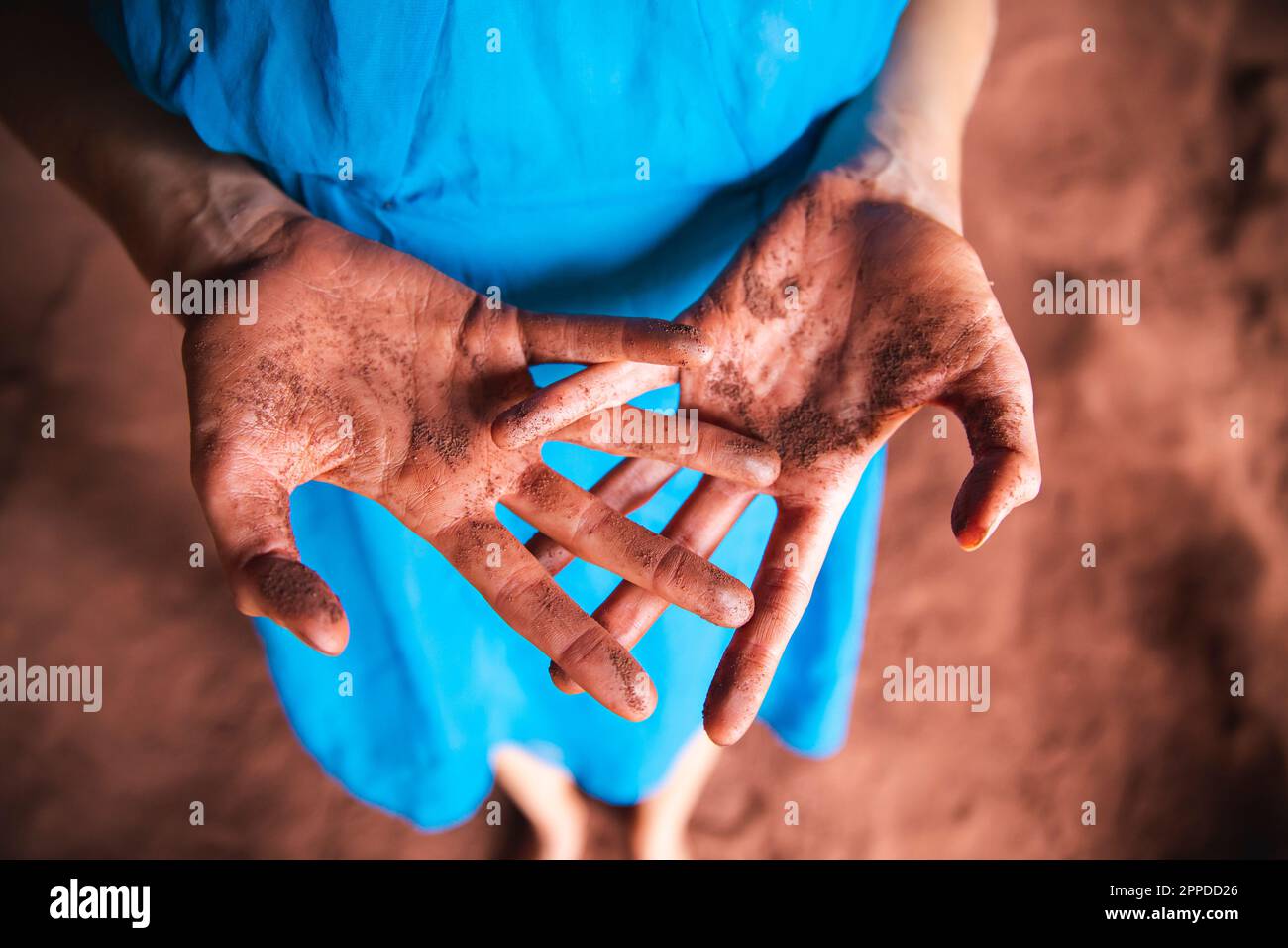 Messy hands of woman with red sand Stock Photo