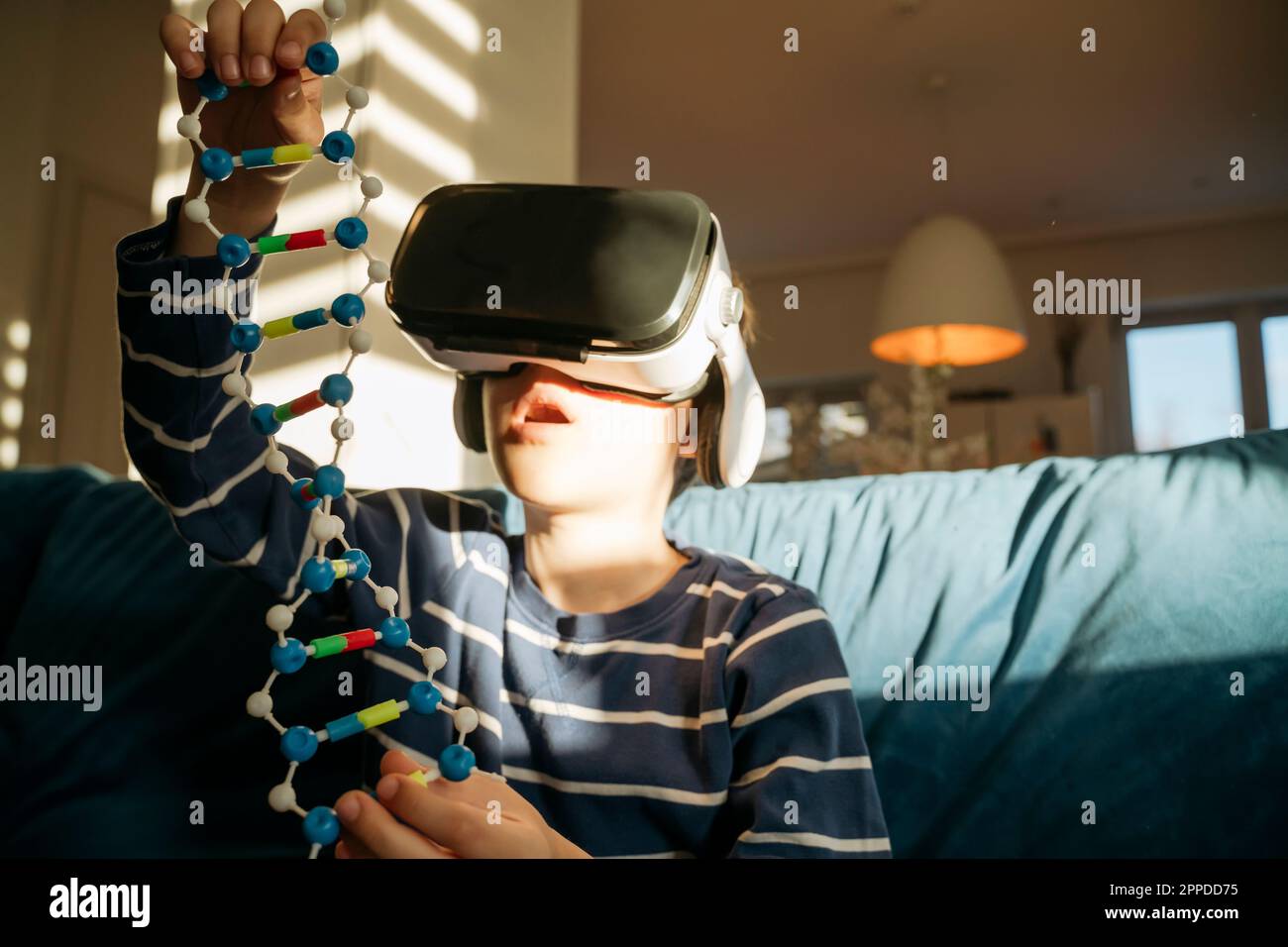 Boy wearing VR glasses examining DNA Stock Photo