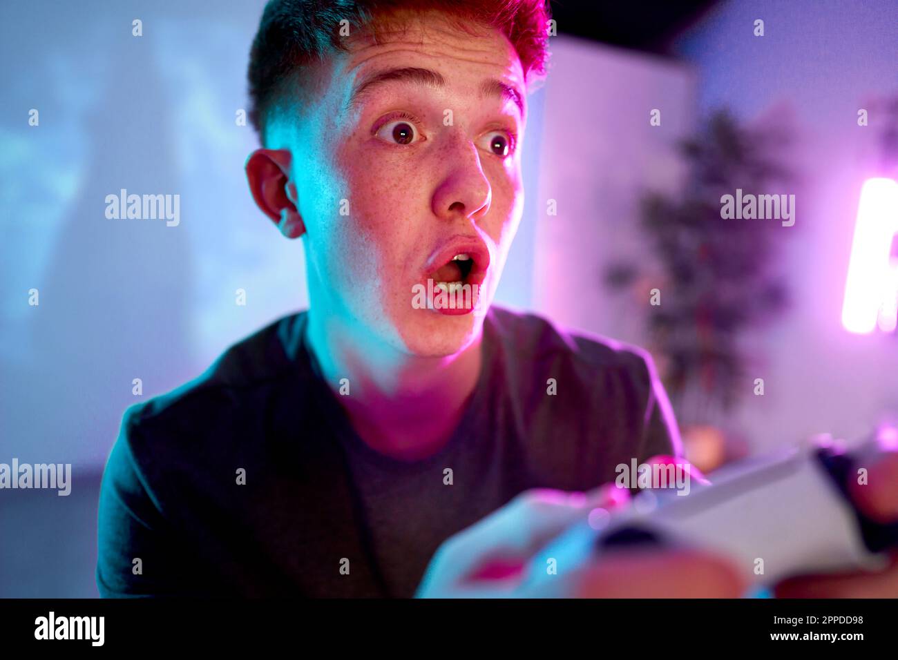Man with facial expression playing leisure game at home Stock Photo
