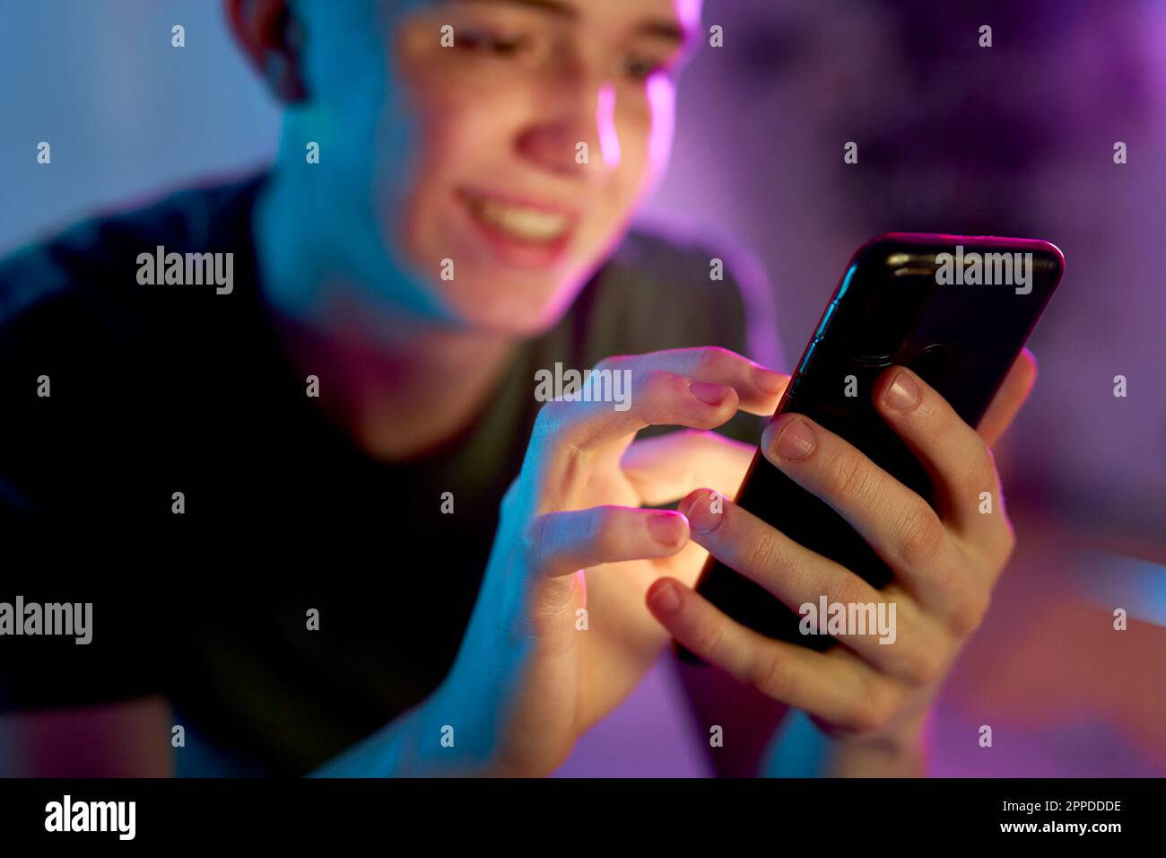 Smiling young man using smart phone Stock Photo