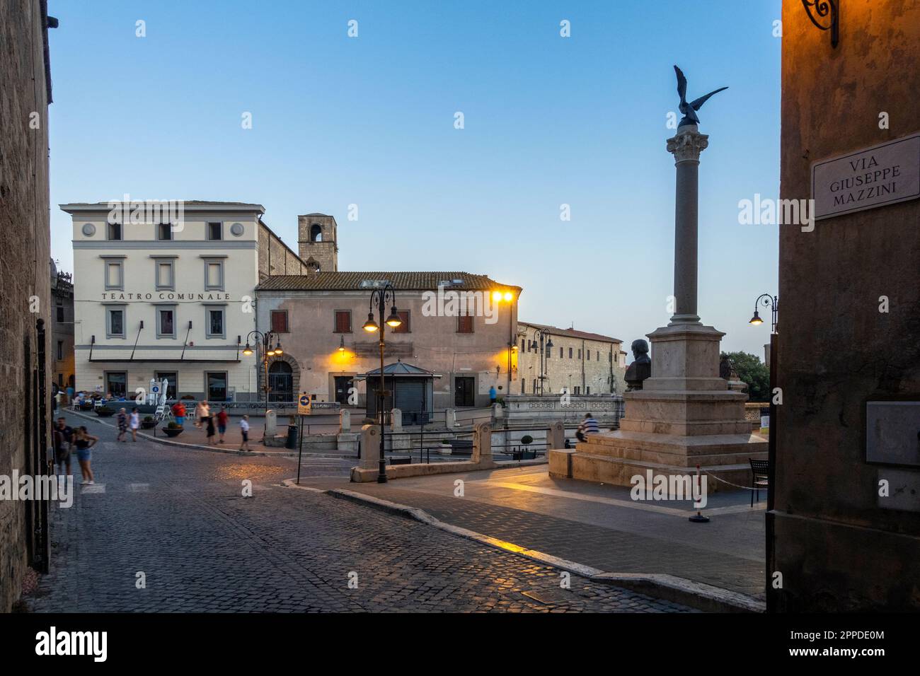 Italy, Lazio, Tarquinia, Piazza Cavour at dusk with Monumento a Giuseppe Mazzini and Teatro Comunale Rossella Falk in background Stock Photo