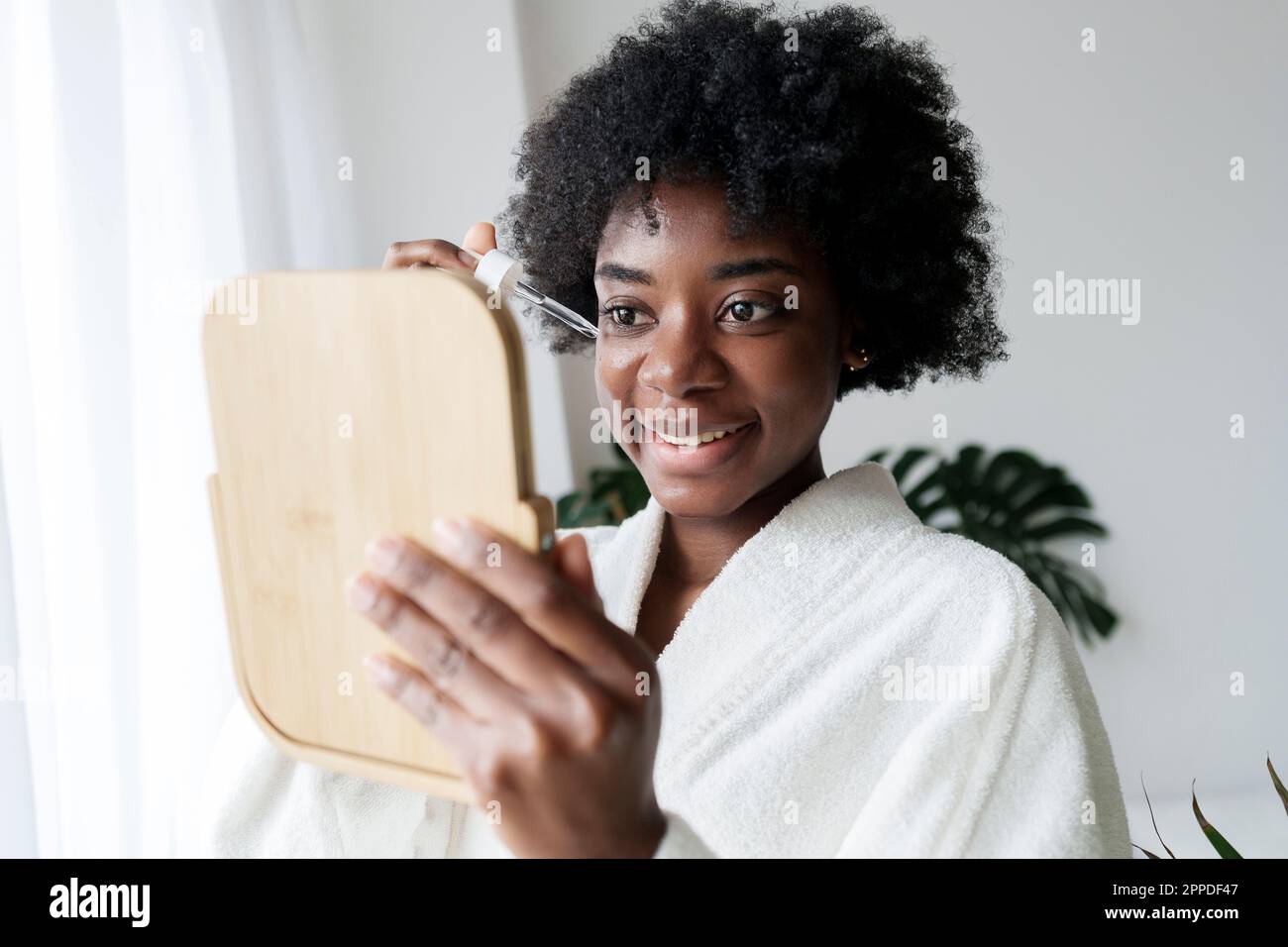 African woman applying serum in hi-res stock photography and images - Alamy