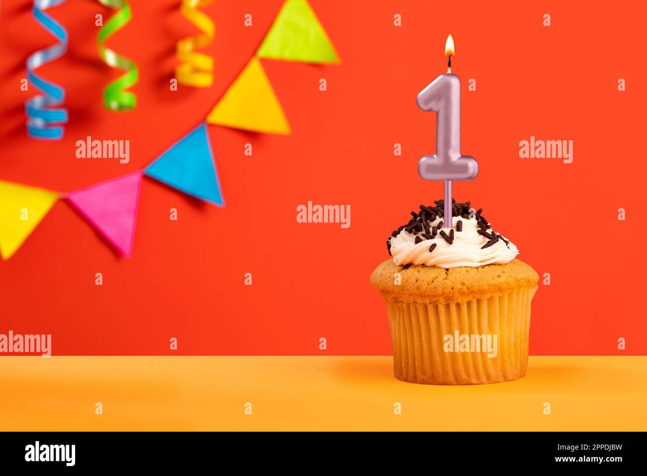 Number 1 Candle - Birthday cake on orange background with bunting Stock Photo
